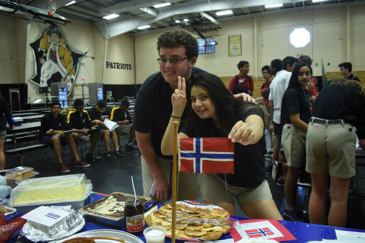 Junior Emily Irigoyen and senior Andrew Kolondra Jr. have fun celebrating Spanish Honor Society’s annual World Food Festival. (Photo/Olivia Lloyd)