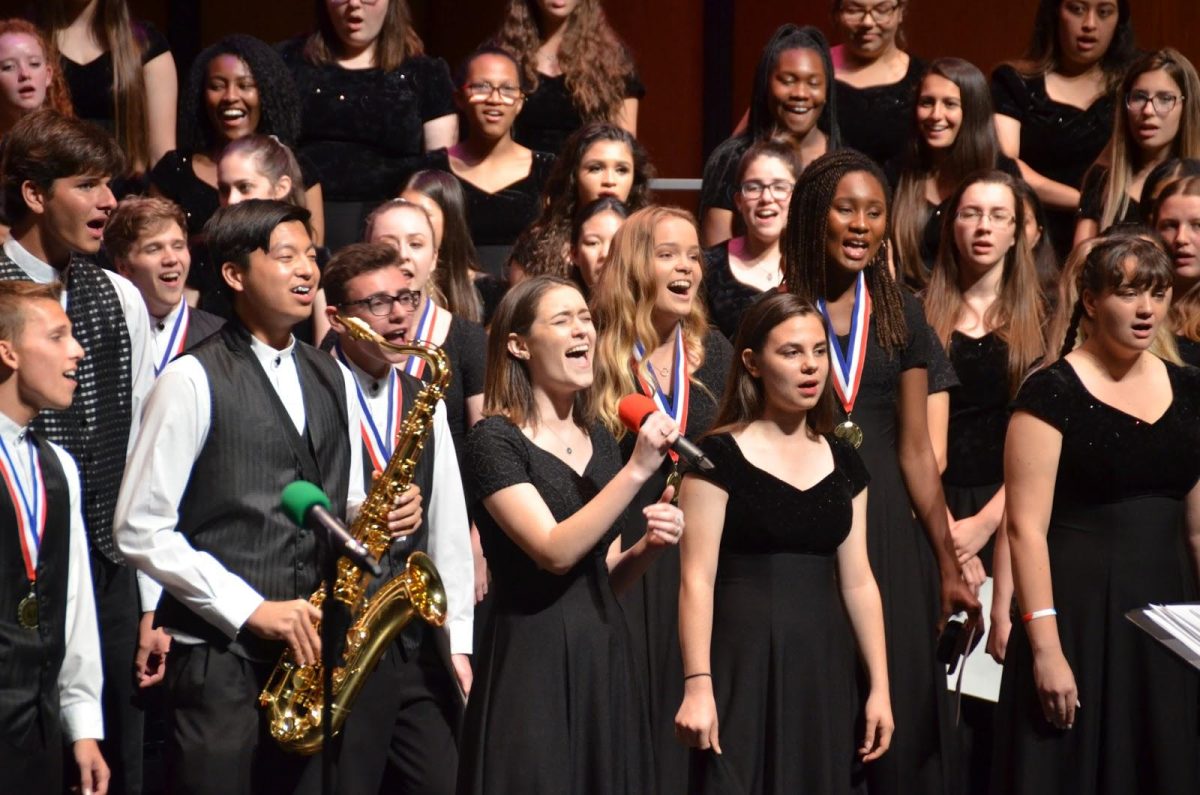 Senior Hannah Ellowitz sings her last solo on the school stage surrounded by her fellow chorus members as they sing “I’ll Make a Difference.” (Photos/Kelly Taylor)