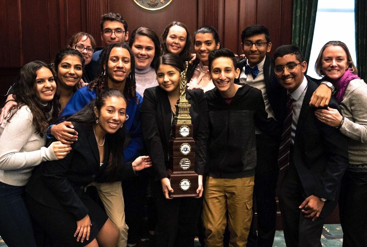 The mock trial team crowds around their championship trophy. The team consisted of Seniors Paris Brock, Emily Irigoyen and Eric Bazail, juniors Rohit Ramesh, Michelle Zapata, Annabella Lugo and Meghan Lannon, sophomores Anika Dham and Aryan Ranjan and Freshman Coby Ackerman, Carolina Sanchez-Torres and Abigail Canalejo. (Photos submitted by Annabella Lugo)
