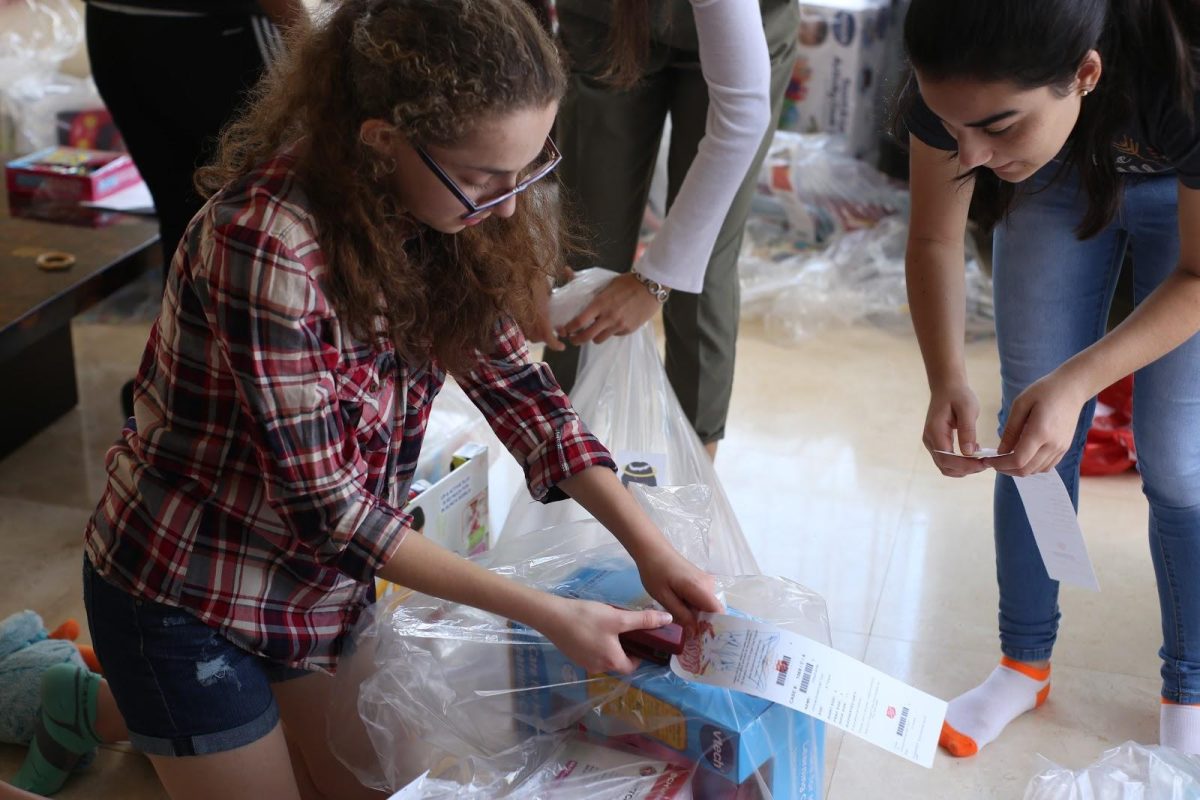 Junior Flora Ranis prepares the gifts purchased with student-raised money. Ranis serves as Vice President of the National Honor Society and organized much of the Angel Tree drive. (Photo/Angela Lin)